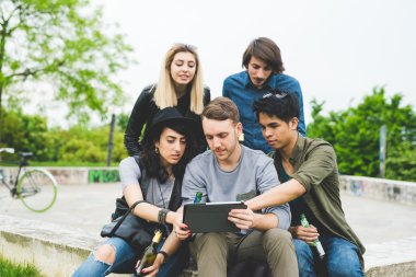 Tablet kullanarak şehirde oturan arkadaşlar