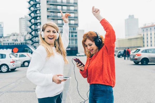 Women listening music with headphones — Stock Photo, Image