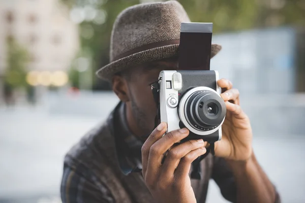 Afro černý muž, který držel instantní fotoaparát — Stock fotografie