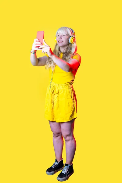 스튜디오는 아름다운 코카서스 여성이 헤드폰을 화면으로 미디어를 셀피를 복용하는 장면을 — 스톡 사진