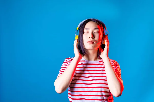 Mujer Asiática Serena Aislado Fondo Azul Escuchar Música Con Auriculares — Foto de Stock