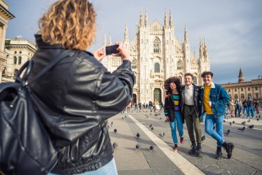 Milano 'daki Duomo Katedrali' nin önünde fotoğraf çekerken eğlenen dört kişilik bir grup insan sosyal ağda anılarını paylaşıyor.