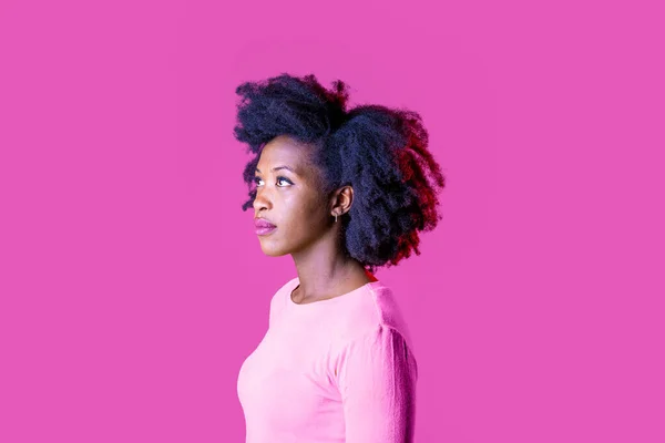 Young beautiful black woman on profile staring serene looking up serious isolated on pink background