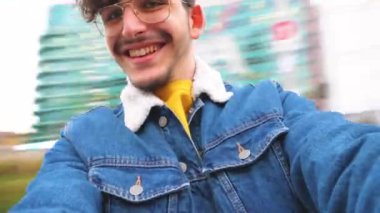 Genç, mutlu, beyaz bir adam gülün etrafında çınlıyor ve keyfine bakıyor.