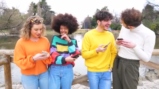 Група Багатоетнічних Друзів Тисячоліть Використовуючи Мобільні Телефони Посміхаючись Щасливо Насолоджуючись — стокове відео