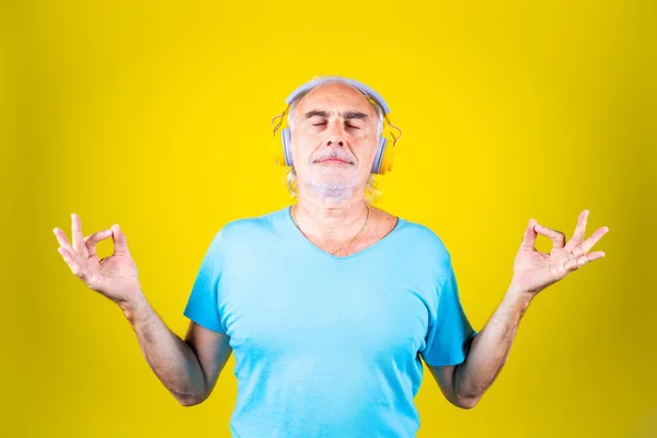 Homem Idoso Fazendo Ioga Fundo Amarelo Concentrando Ouvir Música Meditando — Fotografia de Stock