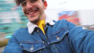 Genç, mutlu bir adam, güllerin etrafında çınlıyor. Keyifli bir şekilde gülüyor.