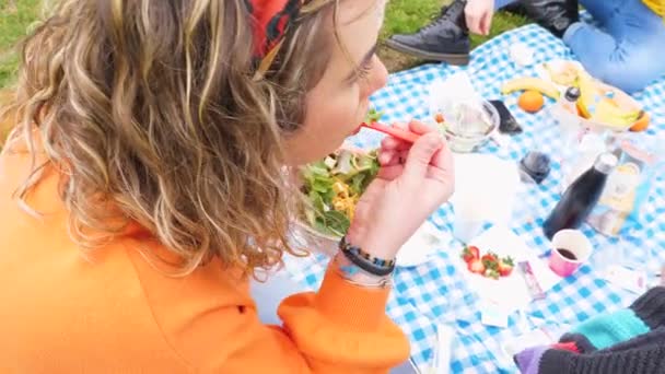 야채를 채식주의자젊은 여성과 공원에서 향정적 사람을 즐기고 샐러드를 — 비디오