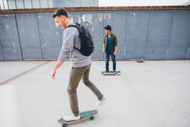 İki sporcu birlikte kaykay yaparak vakit geçiriyorlar. 