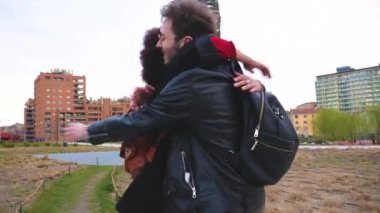 Genç çoklu etnik arkadaşlar uzun zaman sonra buluşup kucaklaşıyorlar, dışarıda gülüyorlar.