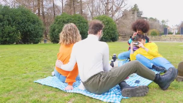 Τέσσερις Χαρούμενοι Φίλοι Ποικίλλουν Πολυεθνική Διασκεδάζοντας Κάνοντας Πικνίκ Ένα Πάρκο — Αρχείο Βίντεο