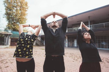 Üç Kafkasyalı genç adam ve kadın parkın dışında antrenman yapıyor.