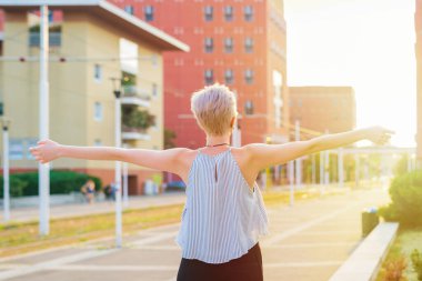 Arkaya bakın. Güzel, beyaz tenli kadın kollarını açıyor. Özgürce dışarıda başarıyı kutluyor.