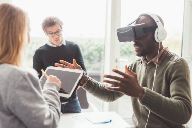 Üç bin yıllık çok ırklı iş insanları 3D izleyici kullanıyor