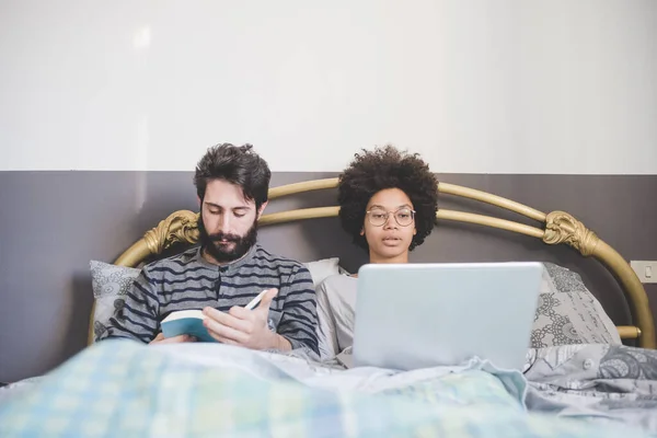 Jong Multi Etnische Paar Bed Met Behulp Van Lezen Boek — Stockfoto