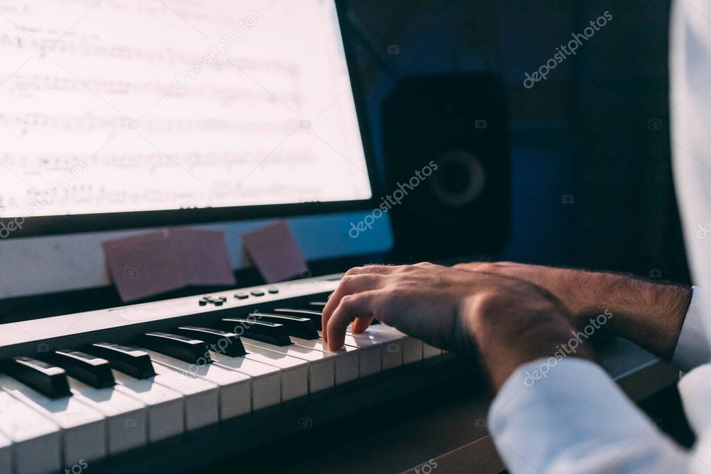 close up young man using pianola and computer