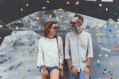 Dışarıda poz veren yetişkin bir çift gözlerinin içine bakıyor.