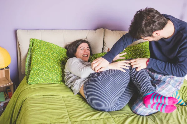 依偎在床上玩乐的一对成年夫妇 — 图库照片