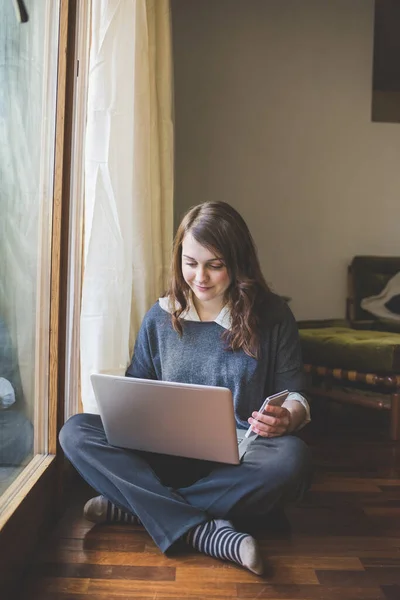 Ung Kaukasiska Kvinna Sitter Hemma Med Hjälp Smartphone Och Dator — Stockfoto