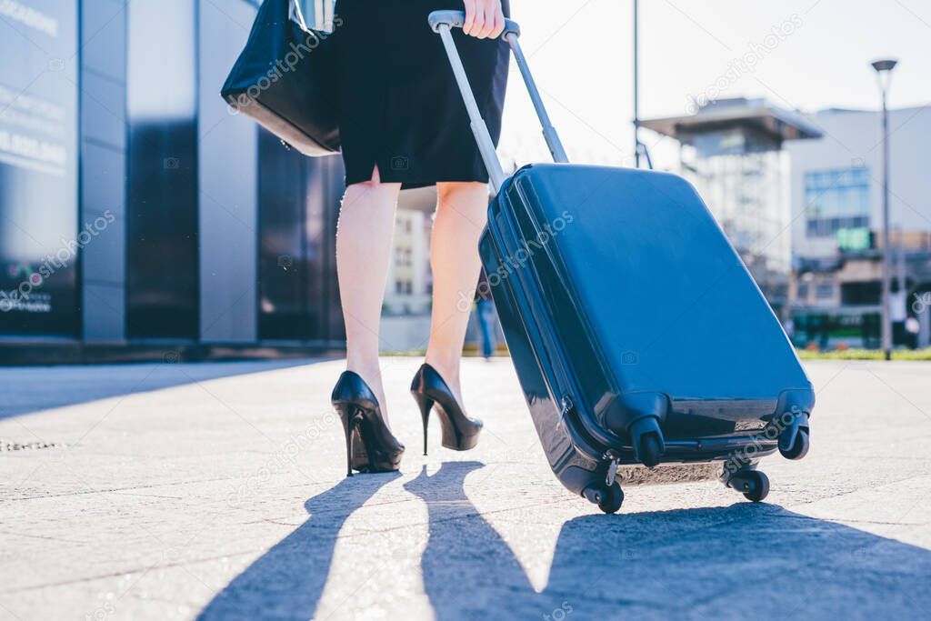 Close up unrecognizable business woman carrying luggage