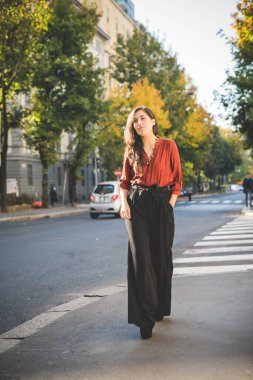 Genç esmer, zarif iş kadını dışarıda yürüyor. 