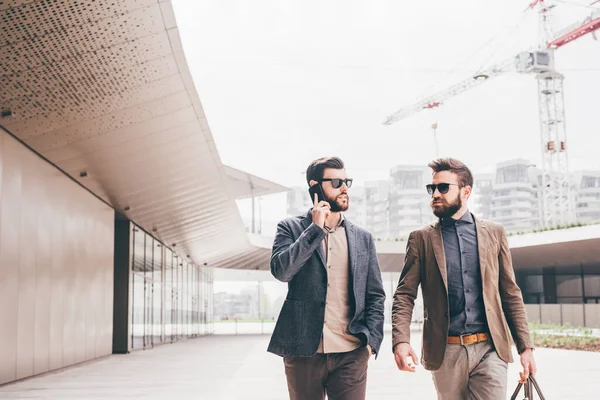 Dos Hombres Negocios Contemporáneos Caminando Hablando Teléfono Inteligente —  Fotos de Stock