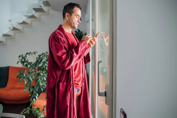Pria Dewasa Dalam Rumah Menggunakan Telepon Pintar Untuk Memeriksa Sekilas — Stok Foto