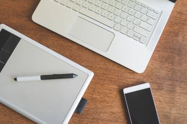 Çalışma masası, çizim masası, defter ve ahşap masadaki akıllı telefonun üst görünümü