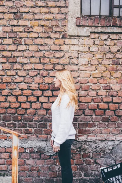 Ung Kvinna Poserar Tegel Vägg Profil Tittar Bort Lyhörd — Stockfoto