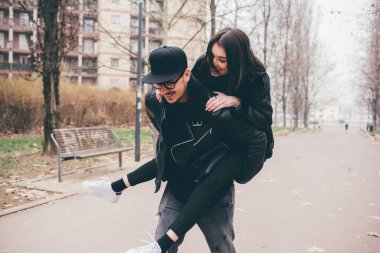 Genç çiftler dışarıda birlikte eğleniyor sırtıma binip gülüyorlar