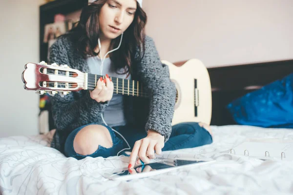 Young Woman Indoor Home Playing Guitar Using Tablet Watching Online — Stock Photo, Image