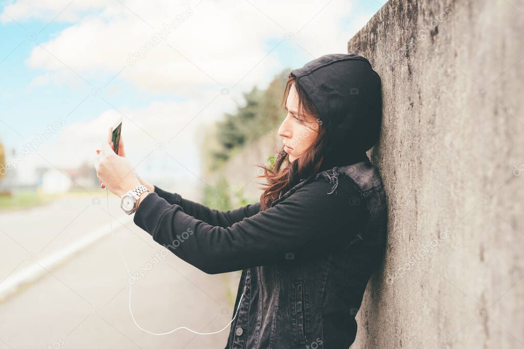 Young woman outdoor taking selfie using smartphone blogging and sharing on social media