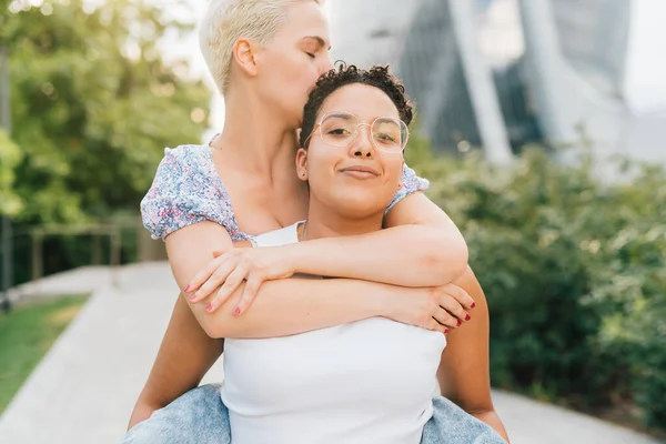 Due Giovani Donne Multietniche Che Abbracciano Cavalcando All Aperto Sorridendo — Foto Stock