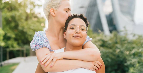 Due Giovani Donne Multietniche Che Abbracciano Cavalcando All Aperto Sorridendo — Foto Stock