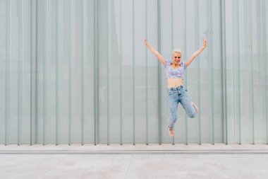 Genç beyaz kadın dışarıda zıplıyor başarıyı kutluyor özgür hissediyorum - reklam boşluğu