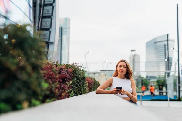 Açık Havada Beyaz Bir Kadın Akıllı Telefon Kullanıyor Kameraya Sakin — Stok fotoğraf