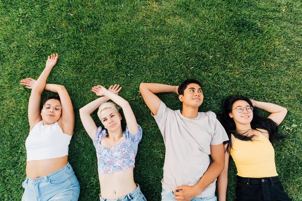 Groep Jonge Multi Etnische Vrienden Buiten Liggend Gras Glimlachend Gevoel — Stockfoto