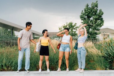 Genç çoklu etnik gruptaki insanlar dışarıda özgürce eğleniyorlar.