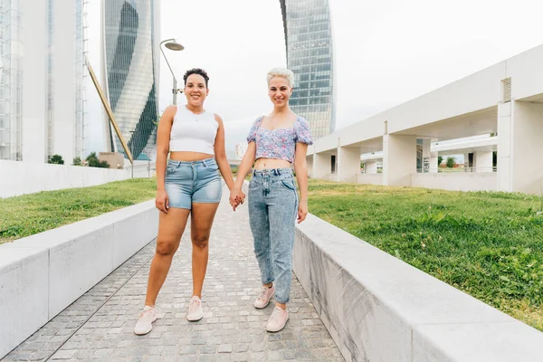 Dos Jóvenes Mujeres Multiétnicas Aire Libre Tomadas Mano Sonriendo Feliz —  Fotos de Stock