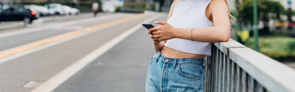 スマートフォンを使用して認識できない若い女性の屋外 広告コピースペースクロップドバナー — ストック写真