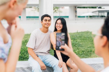 Genç çok ırklı grup arkadaşları dışarıda turist geziyor, birlikte eğleniyor, akıllı telefonla fotoğraf çekiyorlar.