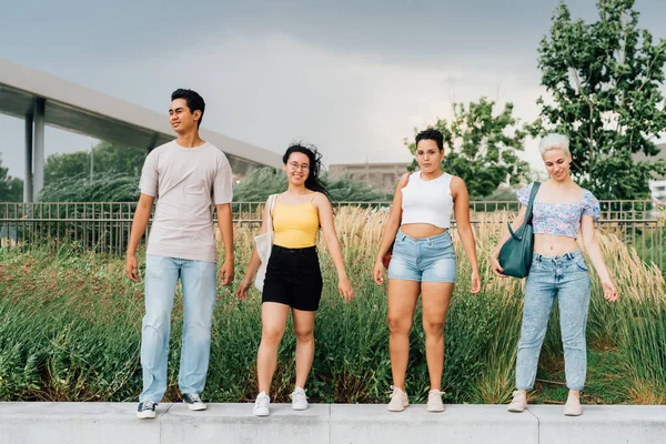 Grupo Jóvenes Muliétnicos Amigos Caminando Aire Libre Posando Día Ventoso — Foto de Stock