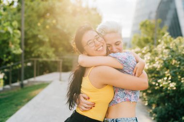 Dışarıda kucaklaşan iki genç kadın uzun bir süre sonra sevgi dolu bir şekilde birbirlerine bağlanıyorlar.