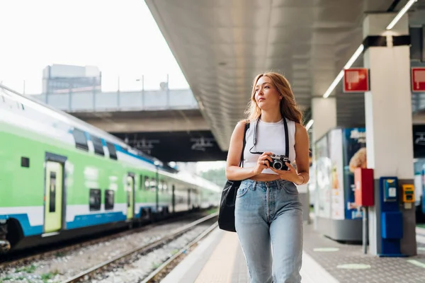 写真を撮る若い白人女性観光客の歩行プラットフォーム鉄道駅 — ストック写真