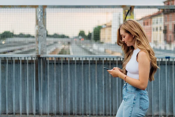 Genç Beyaz Kadın Dışarıda Akıllı Telefon Mesajları Kullanarak Yürüyor — Stok fotoğraf