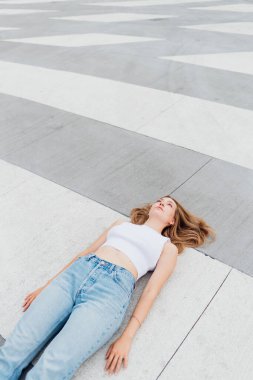 Kafkasyalı genç bir kadın üzgün ve üzgün bir şekilde yerde yatıyor.