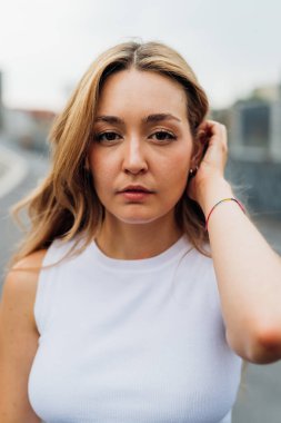 Kafkasyalı genç bir kadının portresi. Açık havada poz veriyor. Geleceğe inanmayı düşünüyor.