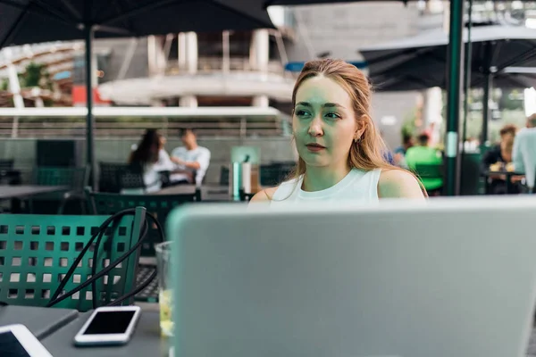 若い白人女性柔軟な労働者リモート作業屋外で座ってコンピュータを使用して屋外 — ストック写真