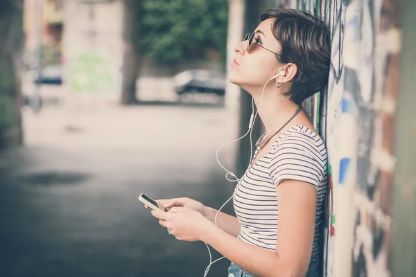 Ung hipsterkvinne som hører på musikk – stockfoto