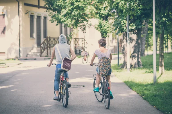 Couple d'amis jeune homme et femme à vélo — Photo